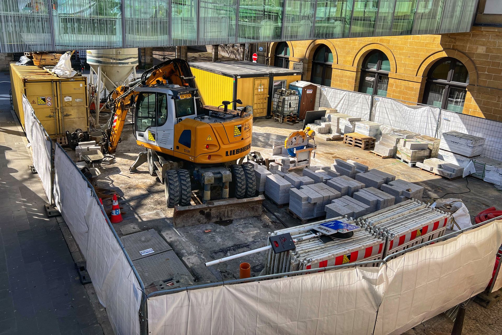 Umsetzung — Baustelle mit Bagger und Baumaterial im vollen Gang