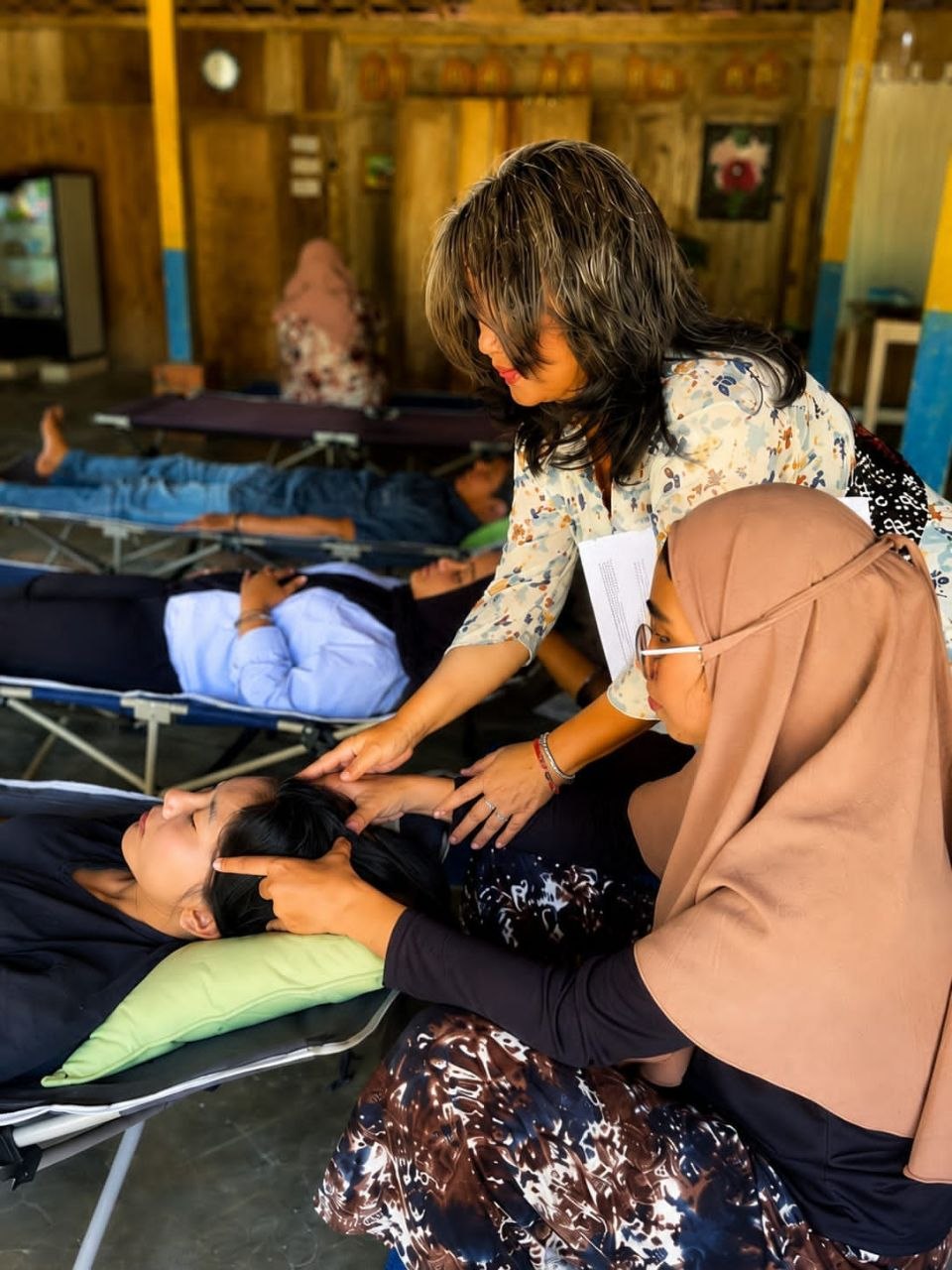 Proses praktik kelas Access Bars di Malang, fasilitator melakukan sesi di area kepala peserta yang berbaring