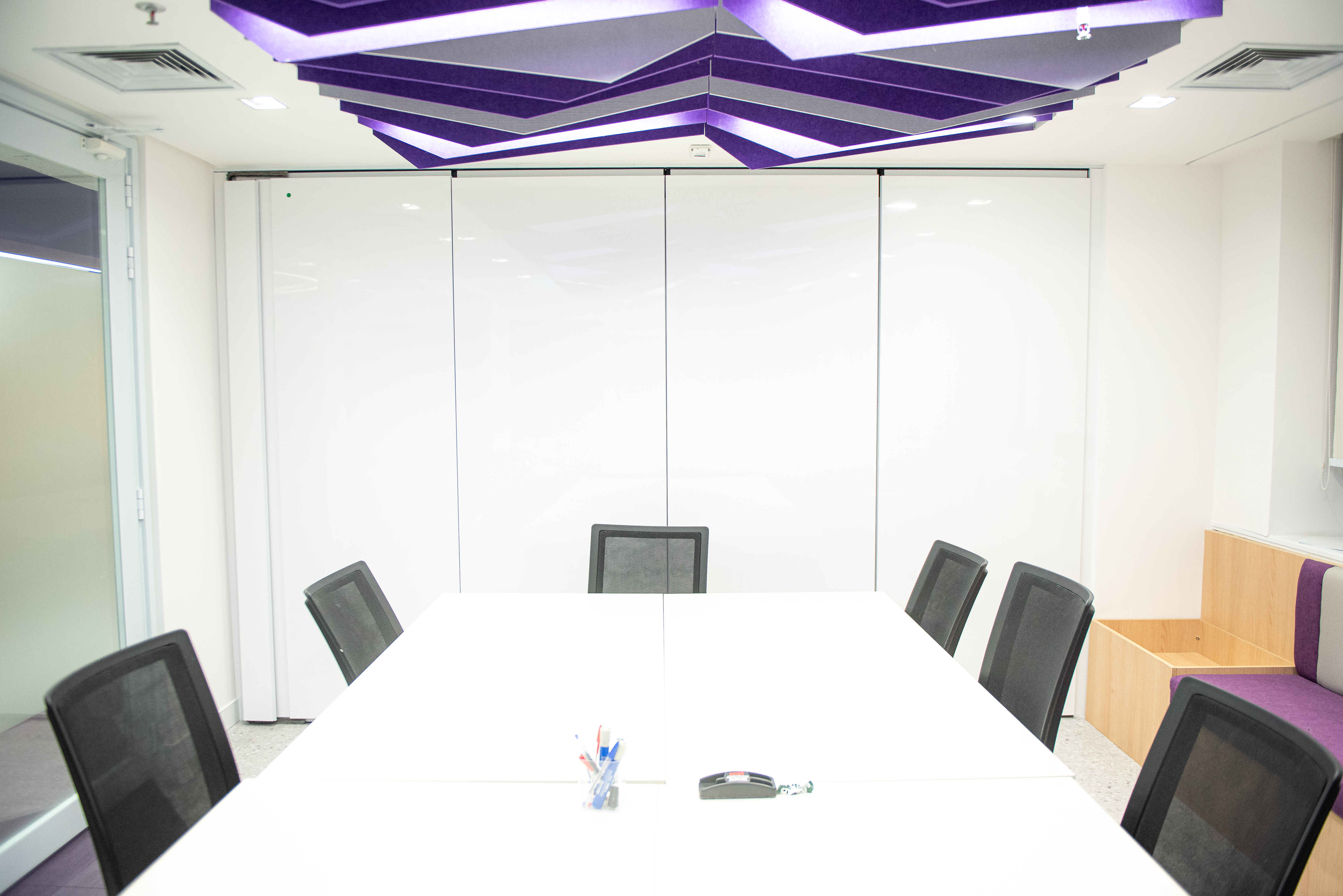 Sala de reunião OLX com divisória retrátil branca e design moderno - DA Divisórias