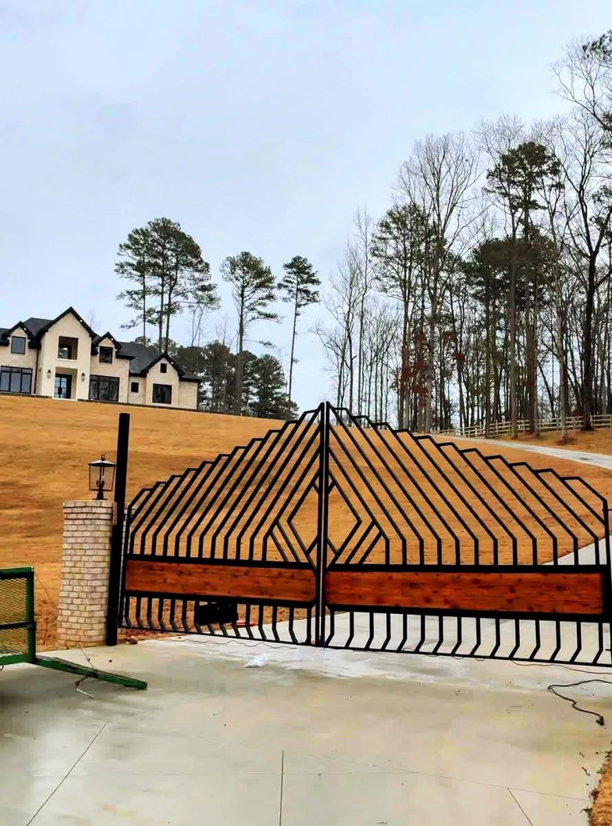 Black iron gate with warm wood accents and brick pillars at a serene residential entrance