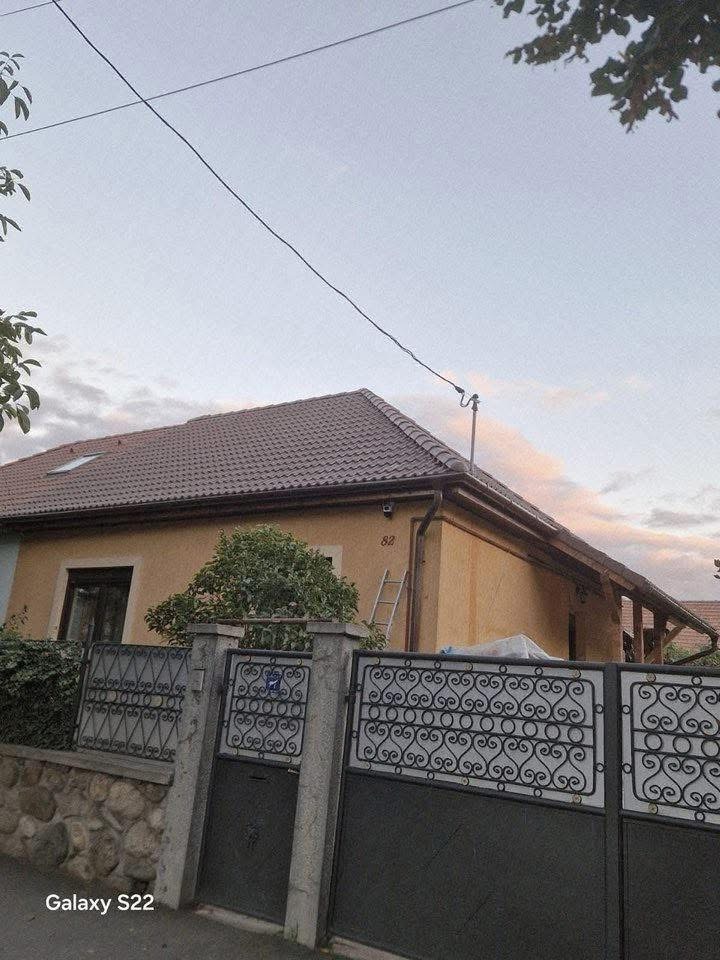 Haus mit Zaun bei Dämmerung – tby Bedachungen