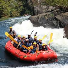River rafting adventure on the Kali River near Areca Jungle Stay Dandeli with group in red raft wearing safety gear