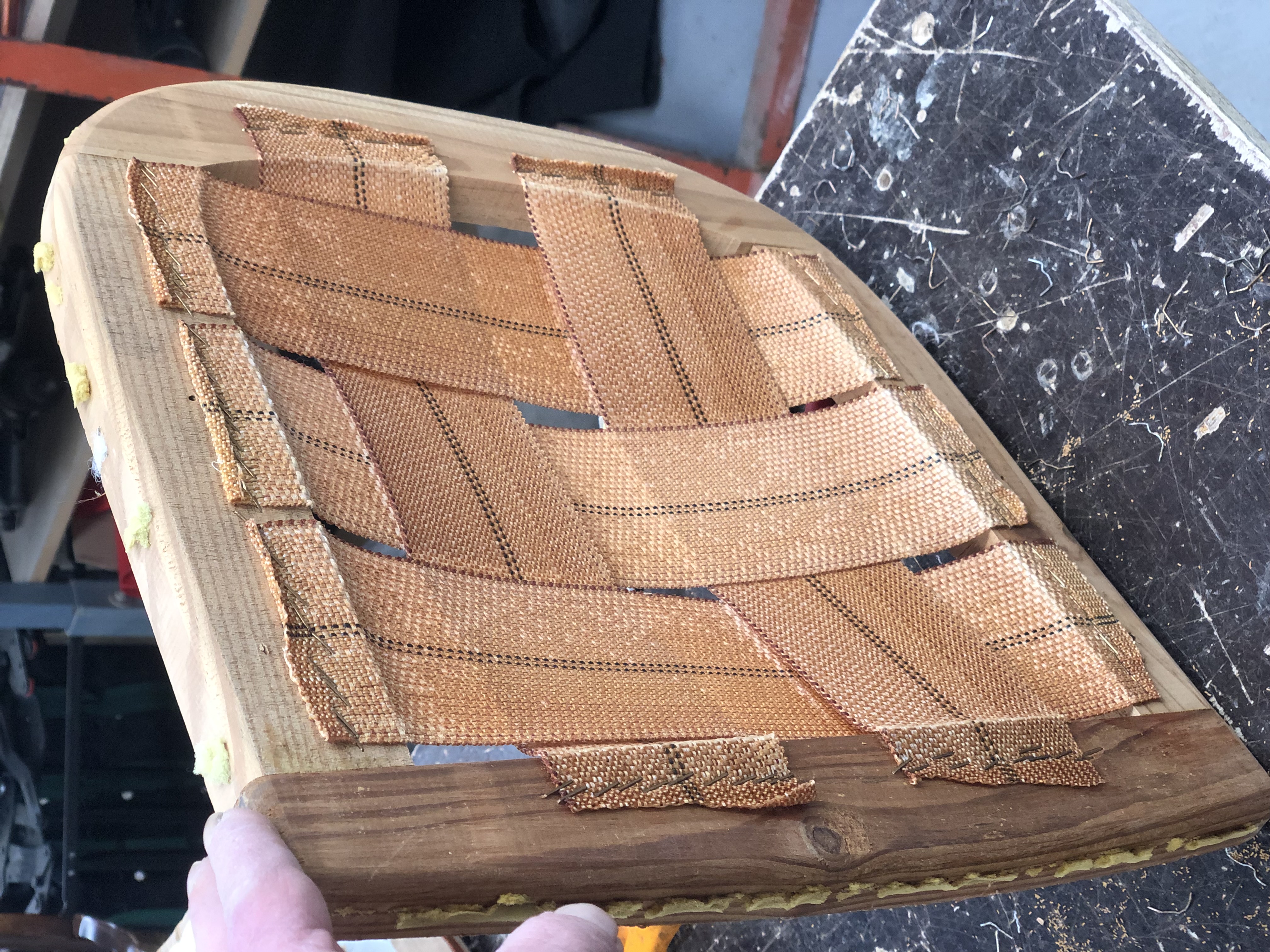 Estructura con cinchas en proceso de tapizado