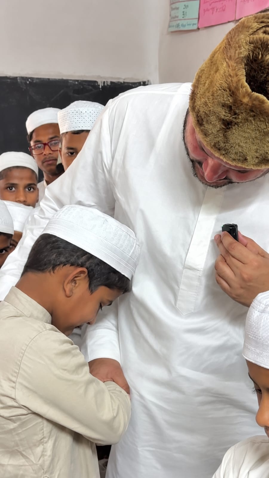 Teacher with children in damaged madarsa
