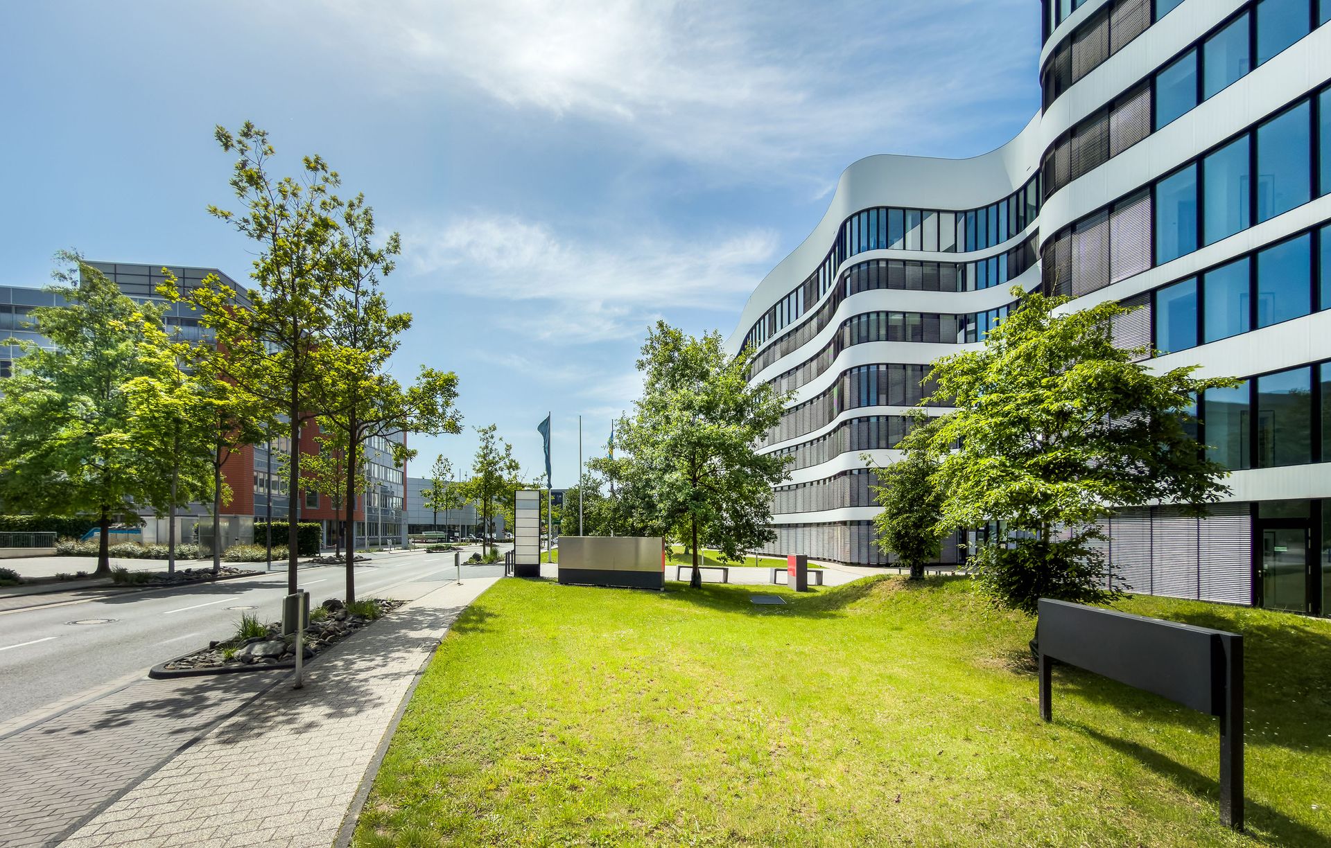 Objektpflege München: moderne Wohnanlage mit gepflegten Grünanlagen, Bäumen und Wegen