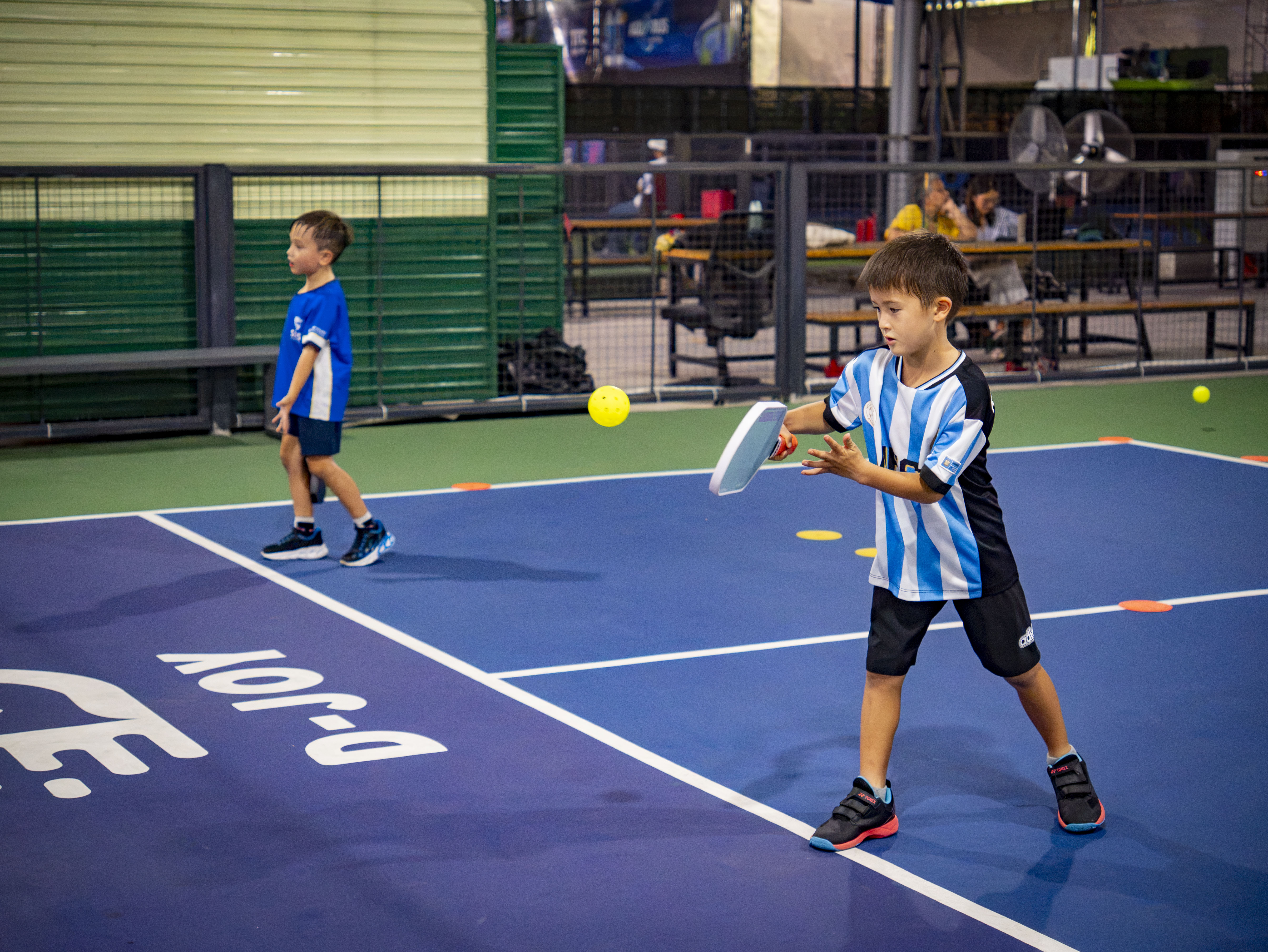 Coach teaching kids pickleball