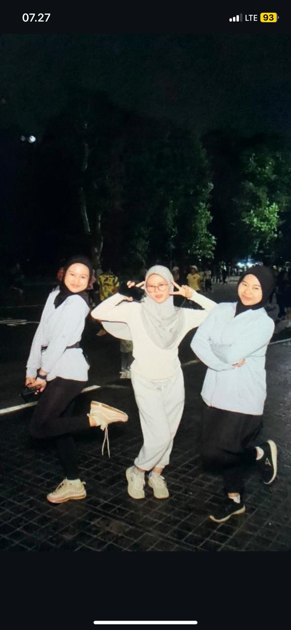 Tiga wanita berfoto di jalan