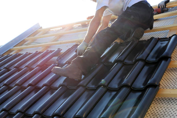 Dachdecker verlegt dunkle Dachpfannen im Sonnenschein