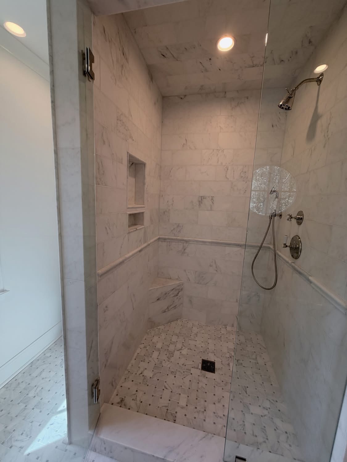 Modern shower with marble tile and glass door