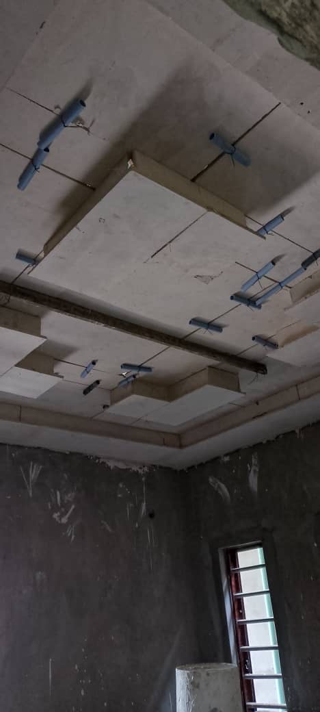 Before: Raw ceiling with blue hangers and grey unfinished walls