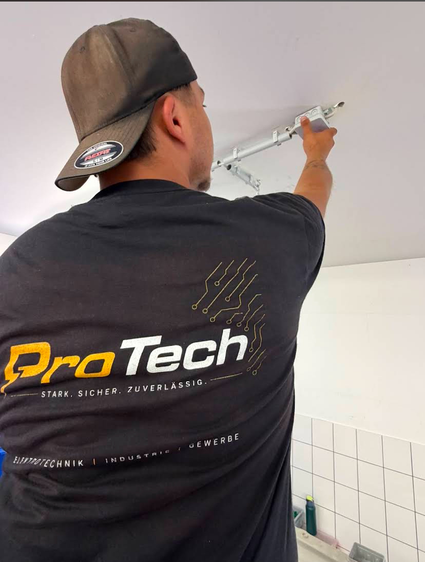 ProTech-Mitarbeiter in T-Shirt mit Aufdruck Stark. Sicher. Zuverlässig. bei der Deckenmontage