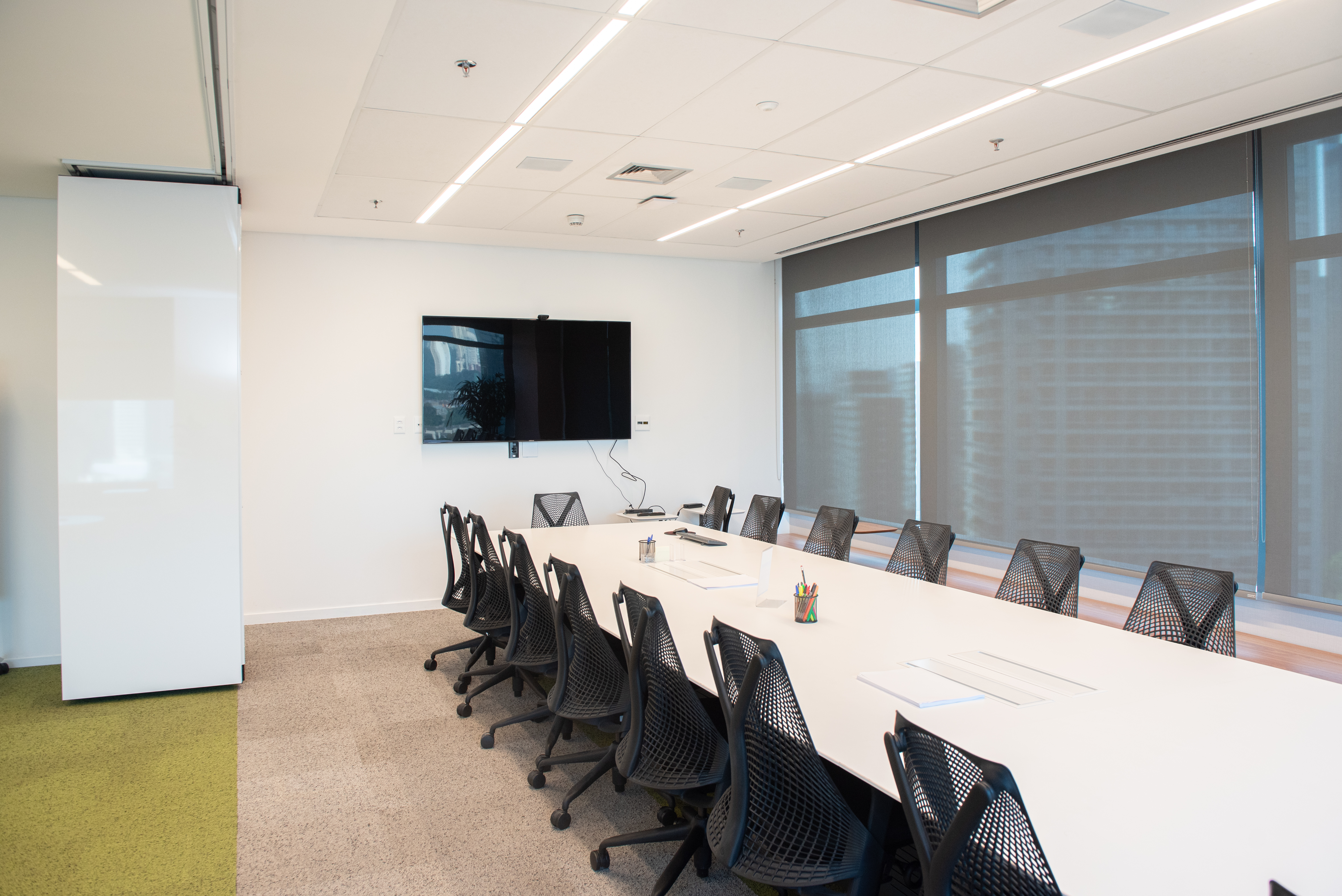 Sala de reunião corporativa com divisória retrátil de vidro - projeto Worley pela DA Divisórias de Ambiente