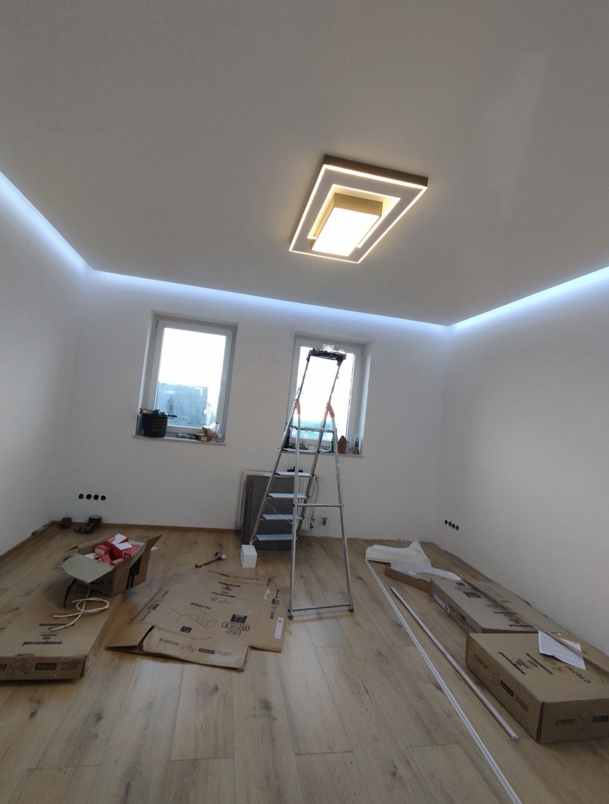 Nachher: fertig gestellter Wohnraum mit Lichtband und neuem Holzfußboden nach Renovierung in Oberhausen