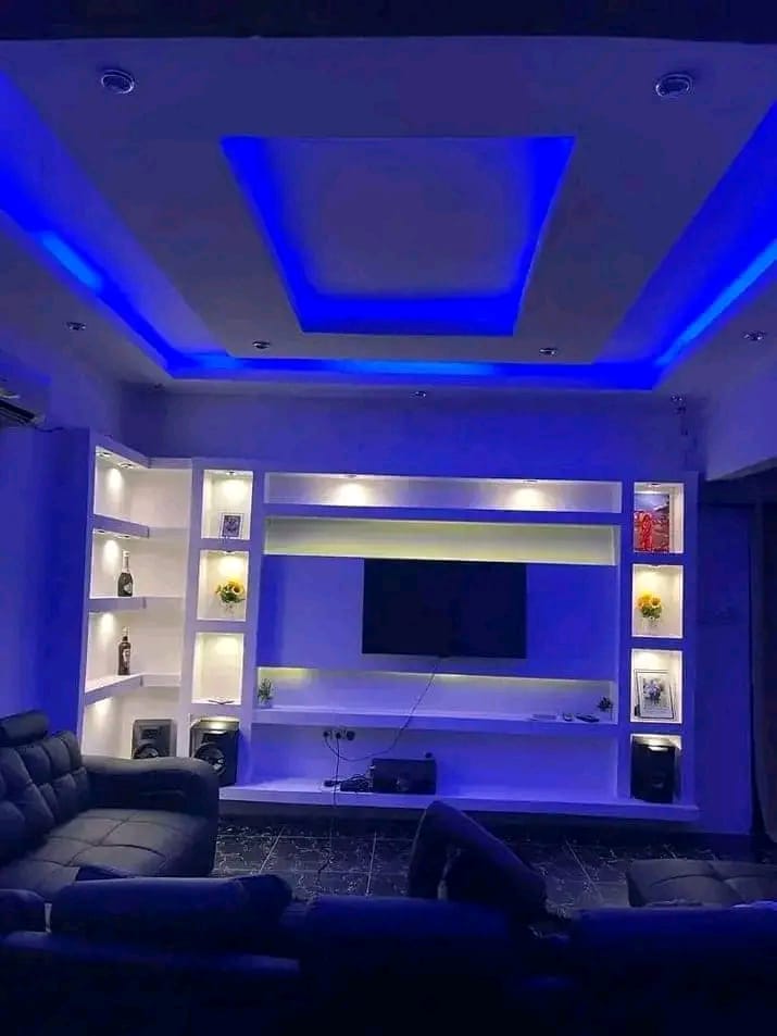 Sala de estar com tecto falso e iluminação indireta azul