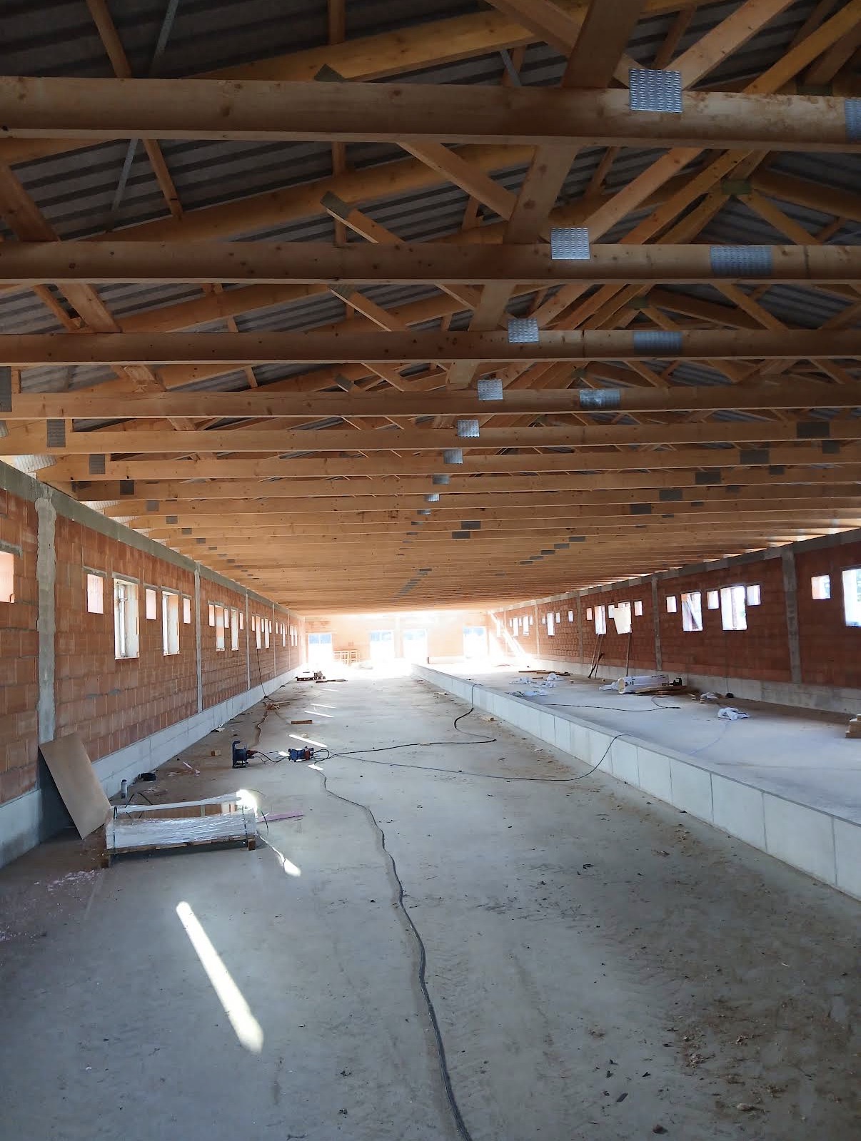 Holzträger-Dachstuhl über Ziegelwänden im Rohbau