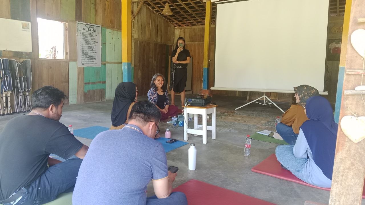 Momen pembelajaran di kelas Access Bars Malang, peserta duduk di atas matras yoga di ruang kayu