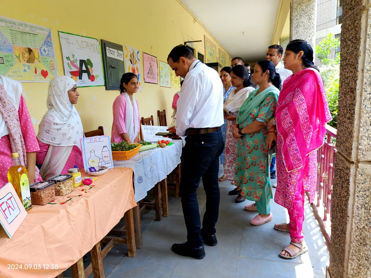 Health theme interactive display with vegetables and traditional attire participants