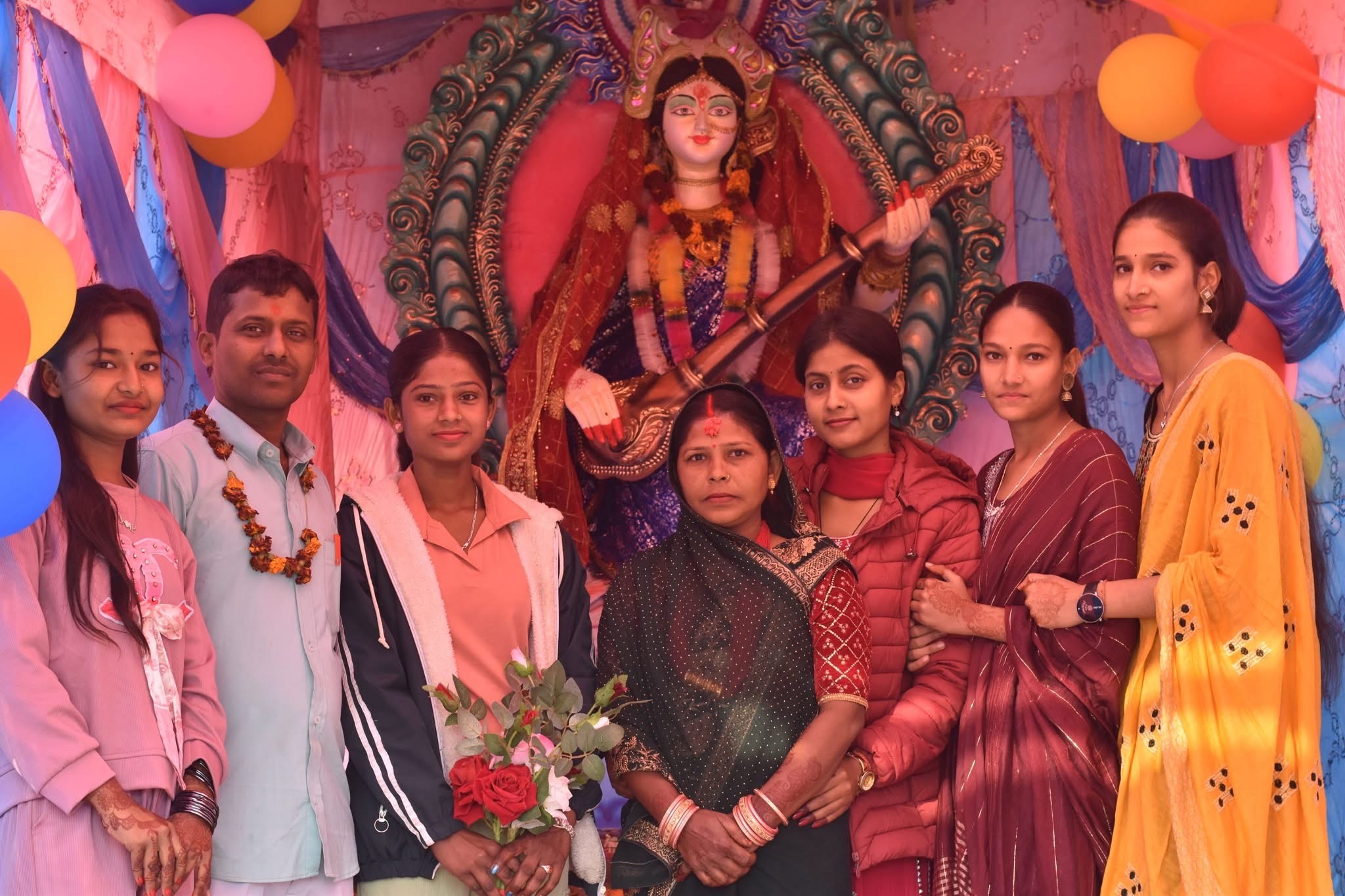 People gathered around decorated deity statue