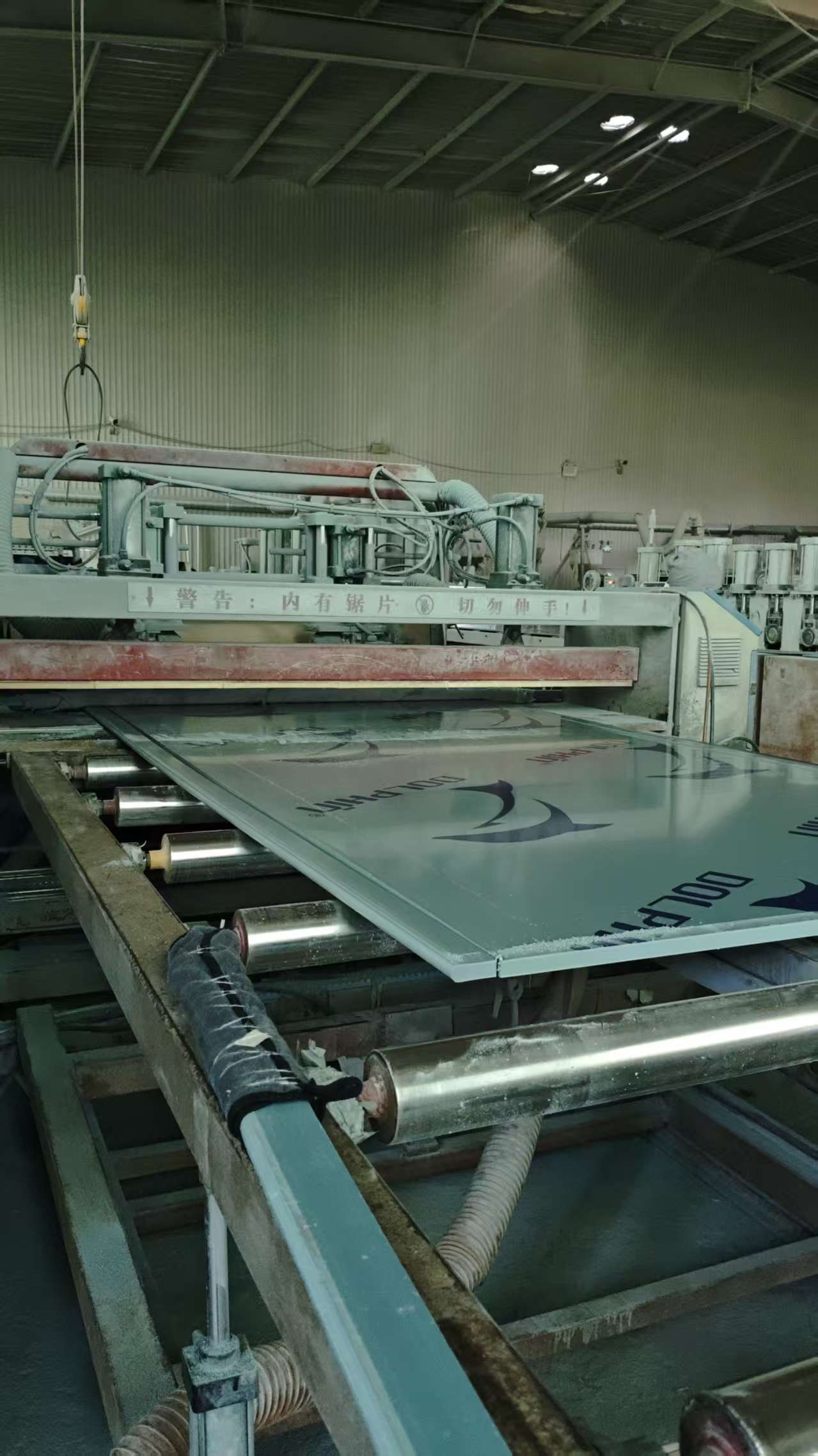 Automated cutting station with saw blade cutting PVC panels to length
