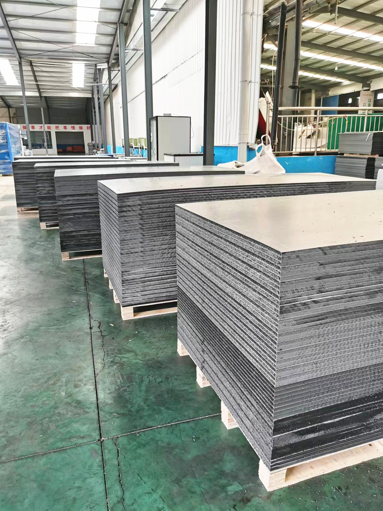Hollow plastic formwork factory warehouse with panels stacked on wooden pallets ready for shipment