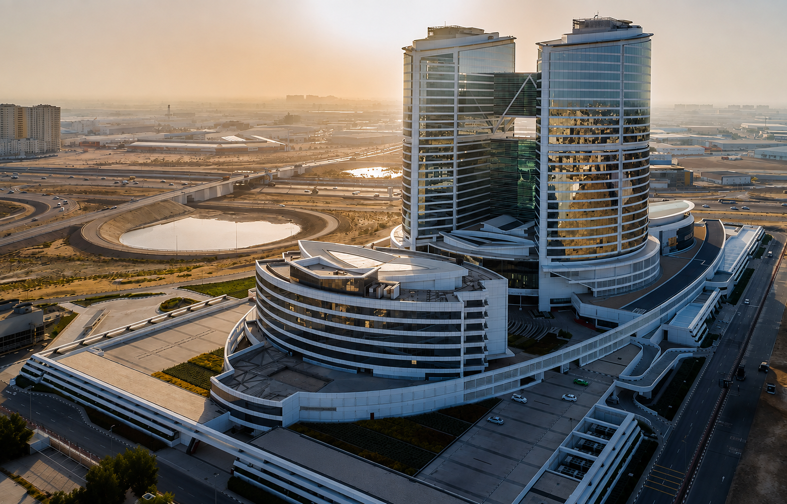 Aerial view of a modern UAE business district with twin glass office towers and surrounding infrastructure, representing company registration in UAE.