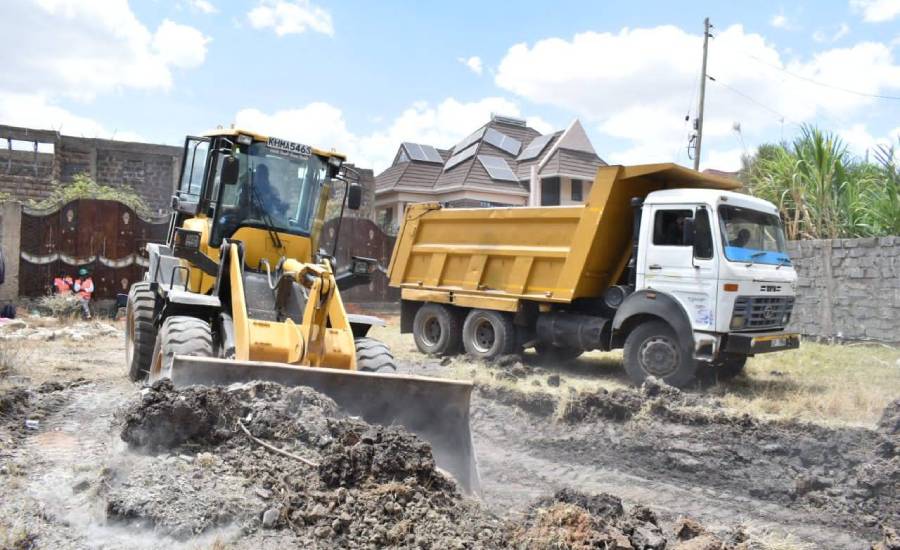 Yellow loader and dump truck on construction site