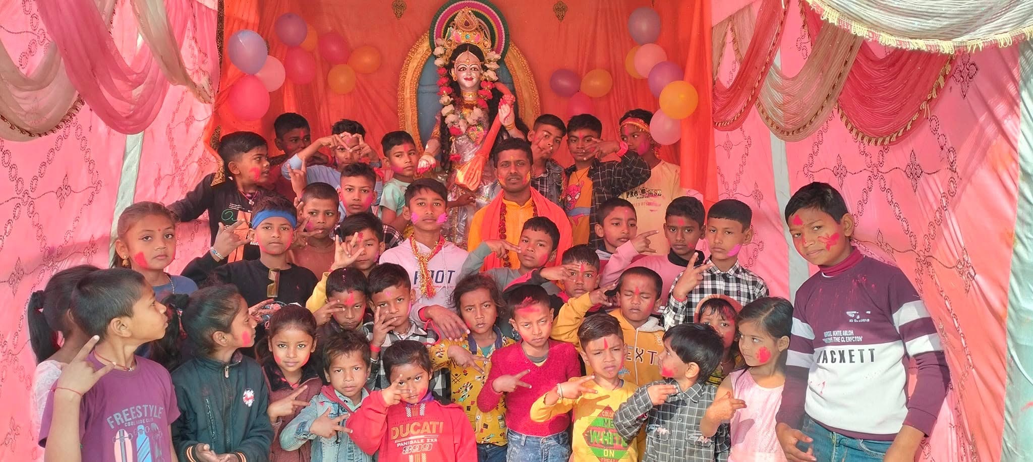 Children with colorful backdrop and deity statue