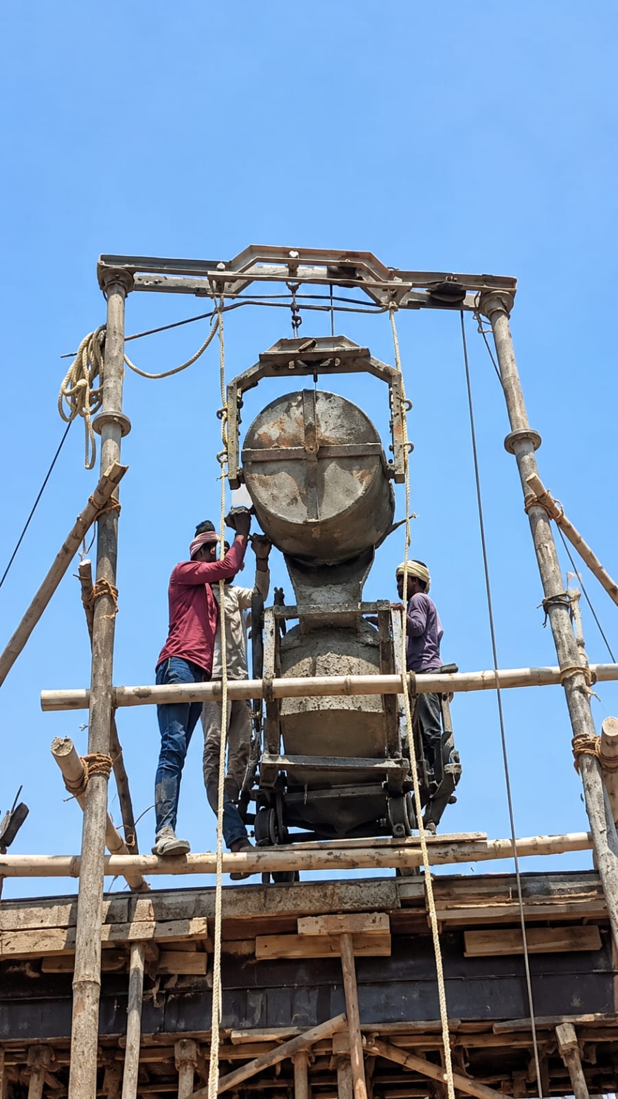 Teen mazdoor scaffolding par kaam kar rahe hain