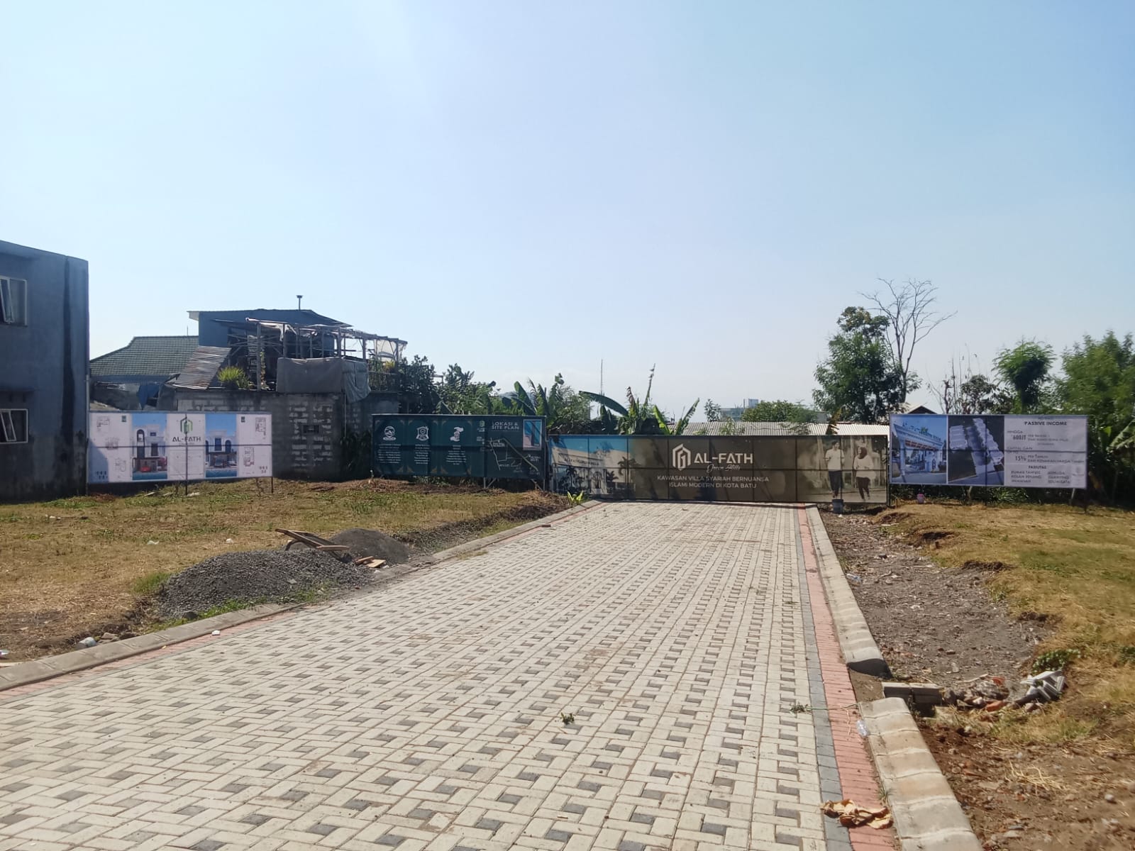 Jalan masuk kawasan dengan hoarding Al-Fath di kedua sisi