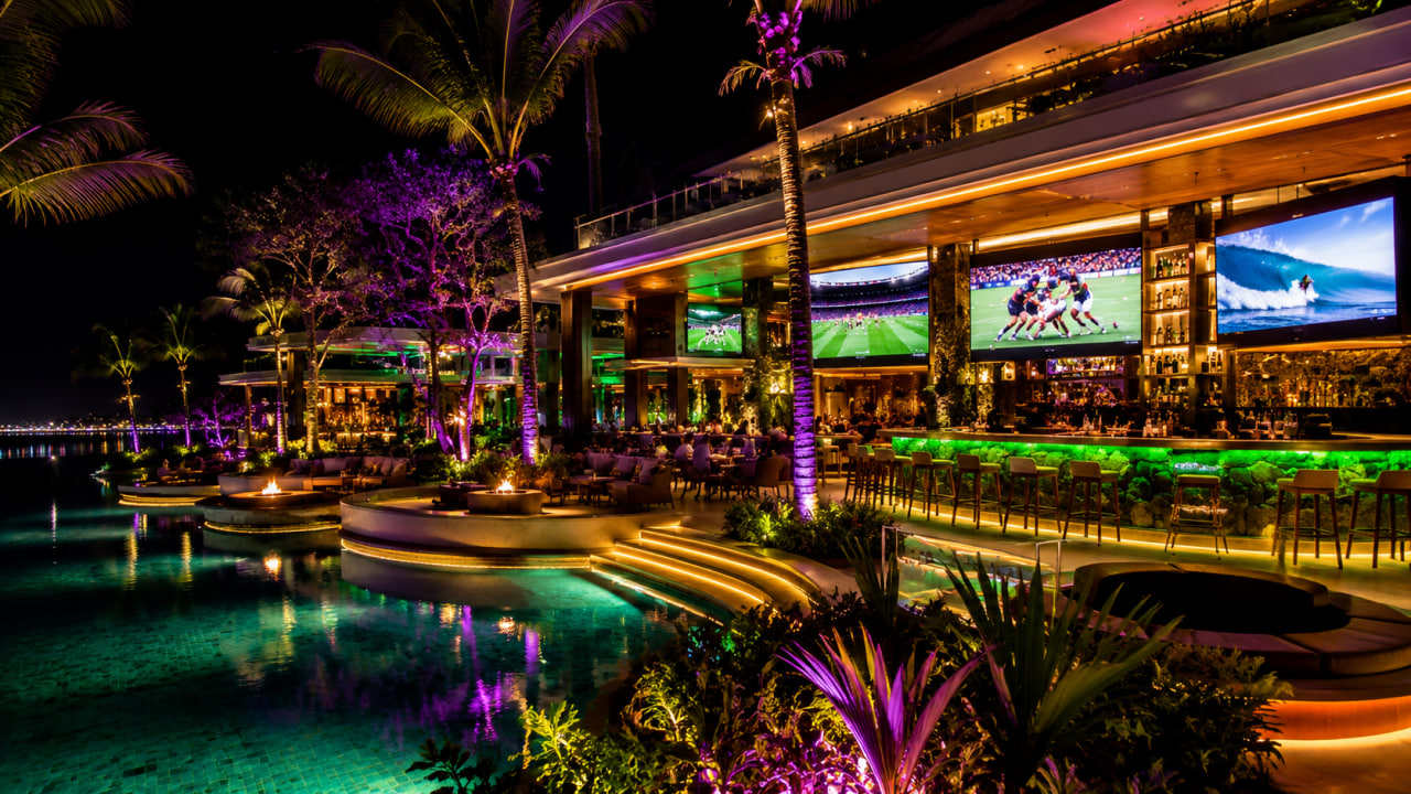 Beyond 17 Bar concept at night with neon lights, massive screens, and Seminyak Bali style pools