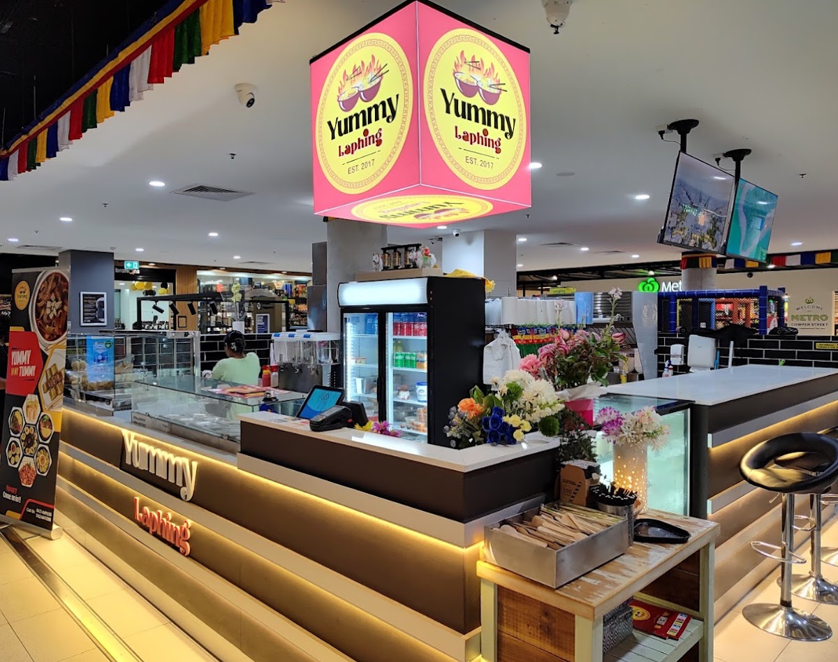 Inside Yummy Laphing restaurant in Granville Place Shopping Village — bright, clean counter with glass display and fresh food